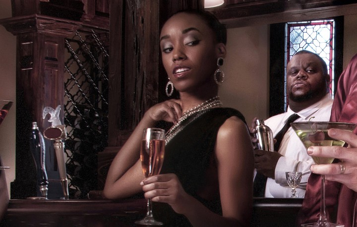 Models surrounding powerful man in pajamas at party